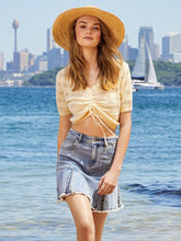 A lady wears a denim skirt.
